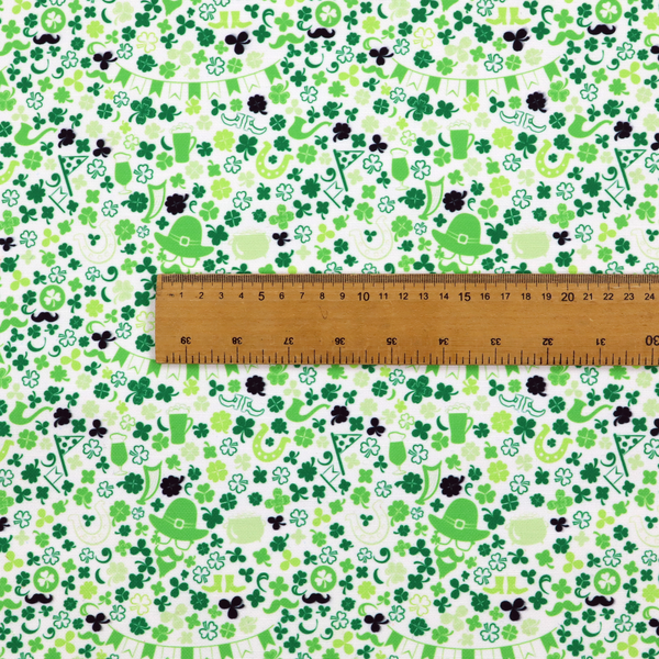 Seamless St. Patrick’s Day fabric pattern on a white background featuring green party bunting banners, frothy beer mugs, leprechaun hats with sunglasses, pipes, horseshoes, and black and green shamrocks.