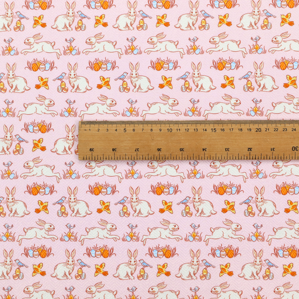 This fabric features a vintage-style Easter meadow pattern on a soft, blush-pink background. The design is reminiscent of classic children’s book illustrations, using fine, orange-brown linework and a muted pastel palette.