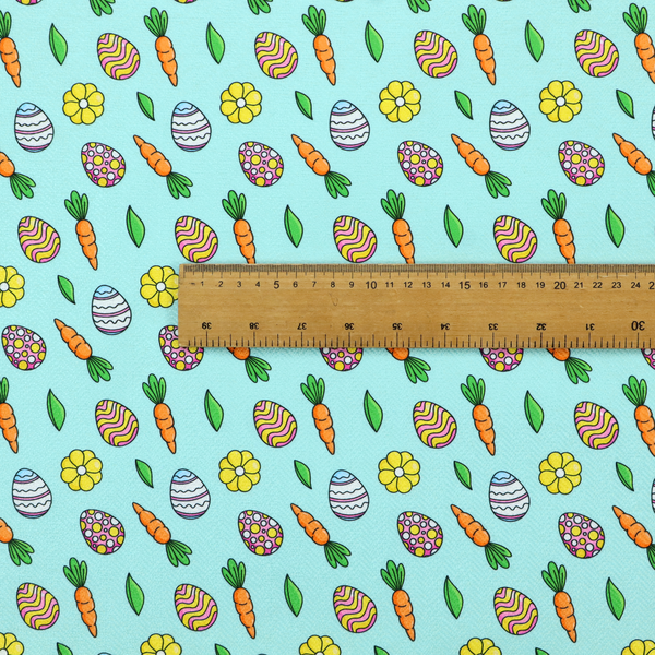 This fabric features a bright and cheerful Easter garden pattern set against a refreshing sky-blue background. The design is clean and energetic, using a cartoon-style illustration technique with bold black outlines.