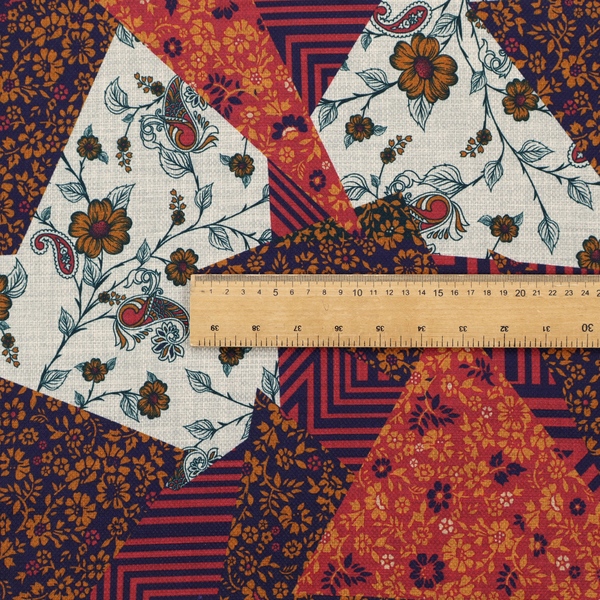 A rich and layered patchwork fabric featuring a collage of sharp, angular shards and geometric fragments. The design blends diverse motifs including vintage-style burnt orange florals, delicate cream botanical vines with paisley accents, and bold navy and terracotta linear chevrons, creating a warm, textured, and maximalist mosaic aesthetic.