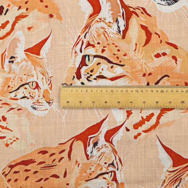 A repeating pattern of illustrated wild cat heads, such as lynxes or bobcats, in shades of orange and cream on a light peach-coloured fabric with a subtle linen-like texture.