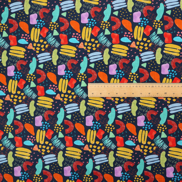 This fabric features a lively, abstract pattern set against a deep navy background. The design is filled with a dense, colourful array of hand-drawn shapes, including squiggles, small arches, and organic blobs in a vibrant palette of yellow, red, orange, teal, light blue, and purple.