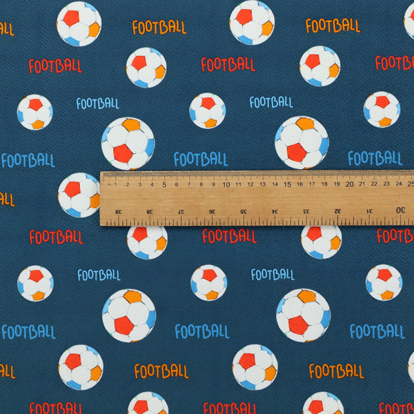 A deep navy blue fabric featuring a lively, repeating soccer-themed pattern.