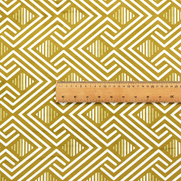 A dynamic geometric pattern with a repeating labyrinth or fretwork motif. The fabric showcases a sophisticated mustard yellow and white colour palette, with crisp white interlocking lines creating diagonal chains and diamond shapes against a warm, golden-yellow background.