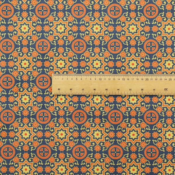 A dense, symmetrical textile pattern featuring a repeating grid of pale yellow eight-pointed stars and orange circular medallions. The motifs are interconnected by delicate orange scrolling vines and tiny floral accents, set against a deep navy blue background. The colour palette consists of mustard yellow, burnt orange, and indigo.