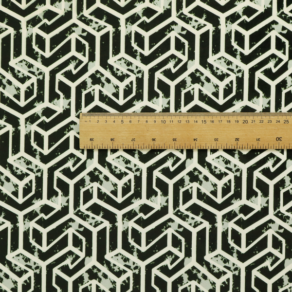 A black and off-white textile fabric featuring a repeating, interlocking geometric pattern. The design consists of off-white outlines that form three-dimensional, isometric maze-like structures against a solid black background. Distressed, pale green speckled textures are subtly integrated into the background spaces, giving the sharp, structured design a weathered, organic touch.
