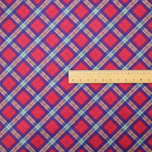 This fabric features a diagonal plaid pattern, creating a diamond-shaped grid. The design is composed of bold magenta squares framed by dark blue and thin white intersecting lines.