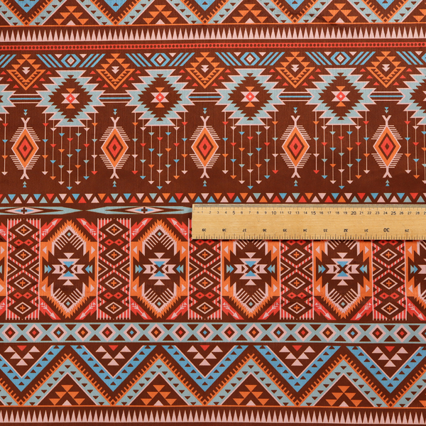 A brown fabric pattern featuring southwest-inspired geometric bands with zigzags, diamonds, and native-style motifs in terracotta, light blue, and cream.