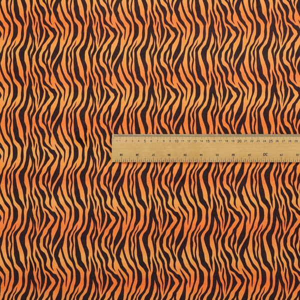 Fabric featuring a dense, repeating animal print pattern of vertical black tiger stripes over a vibrant orange background.