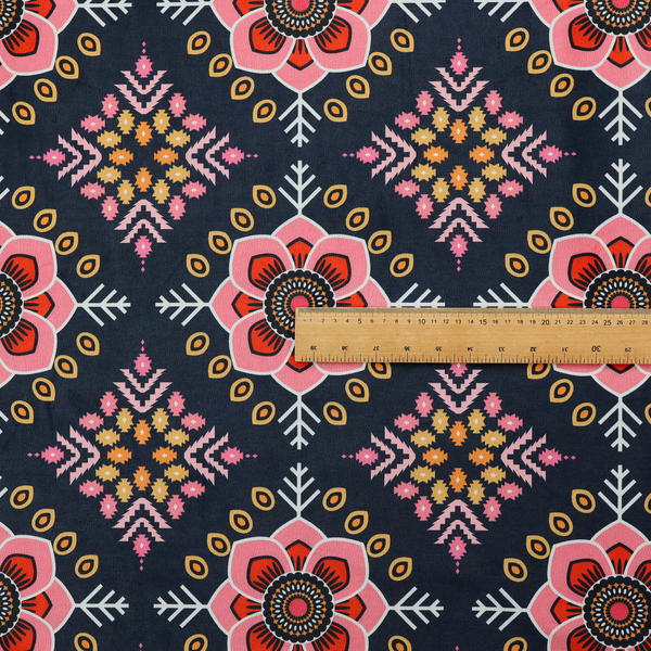 A repeating folk-art textile design featuring alternating rows of stylized pink floral blossoms and intricate diamond-shaped geometric motifs.