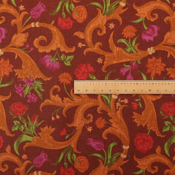 A repeating pattern of ornate, golden-orange baroque scrolls and acanthus leaves intermixed with detailed botanical elements including red roses, magenta tulips, and green foliage, all set against a deep crimson red background.