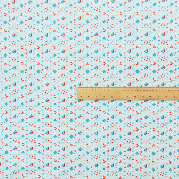 Light blue fabric featuring a small-scale repeating nautical pattern of red anchors, lifebuoys, and sailboats, interspersed with blue and red stars.