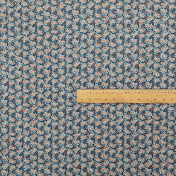 A dark blue and slate textured fabric featuring a dense, repeating mosaic pattern of small tropical leaves in shades of cream and rust orange.