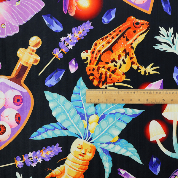 A vibrant, repeating mystical pattern on a black background featuring illustrated mandrake roots with faces, orange frogs, purple moths, glowing fireflies, potion bottles filled with eyeballs, ornate golden keys, luminescent mushrooms, lavender sprigs, and scattered crystals.