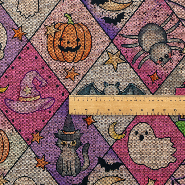 A Halloween-themed harlequin pattern fabric with diamond-shaped sections in purple, pink, and beige, featuring cartoon illustrations of Jack-o'-lanterns, a witch's cat, ghosts, bats, skulls, spiders, stars, and crescent moons.
