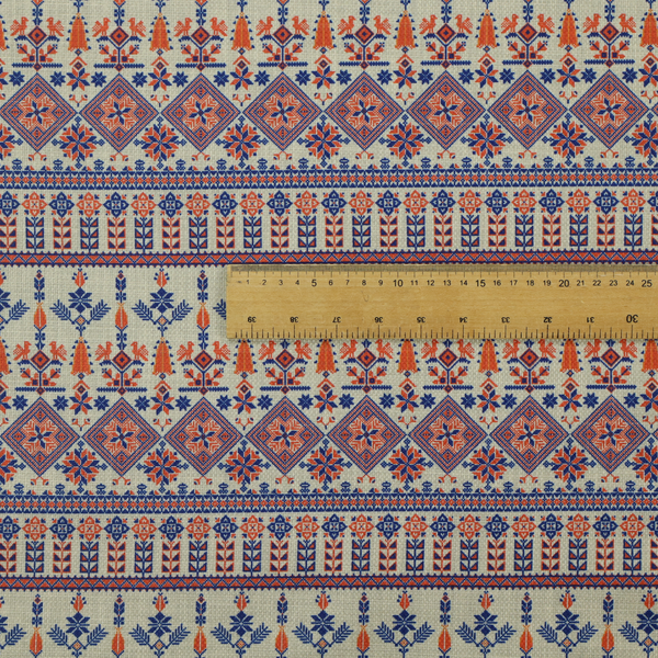 Intricate folk-inspired fabric featuring horizontal bands of geometric diamonds, stylized birds, and floral motifs in navy blue and rust orange on a beige background.
