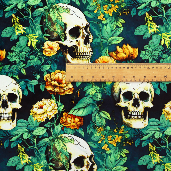 A detailed repeating pattern on a dark background featuring ivory human skulls entwined with vibrant green leafy vines and blooming yellow and orange flowers.