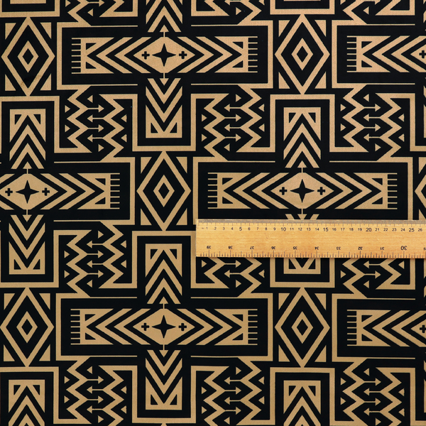 Black and gold geometric fabric featuring an intricate Navajo-inspired tribal pattern with chevron lines, diamonds, and cross motifs.
