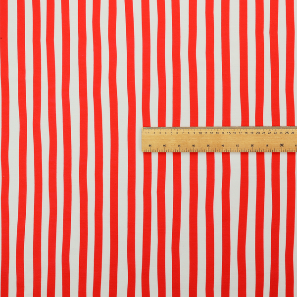 A white fabric patterned with vertical, hand-drawn red stripes that feature a slight, organic waviness.