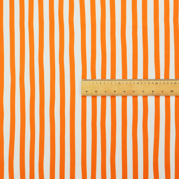 A white fabric patterned with vertical, hand-drawn orange stripes that feature a slight, organic waviness.