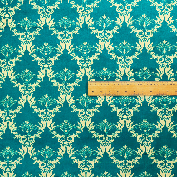 The image features an intricate, repeating damask pattern in a light cream colour set against a textured teal background.