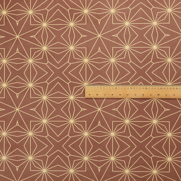 A geometric upholstery fabric featuring an intricate, repeating starburst and lattice pattern in cream lines on a warm terracotta brown background.