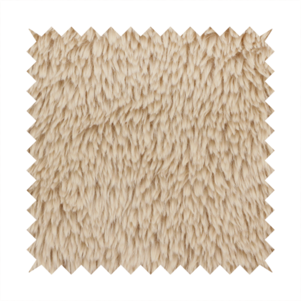 A tan or light beige, high-pile faux fur fabric. It has a dense, plush, and cosy texture with soft, slightly tousled fibres that create a shag-like appearance.