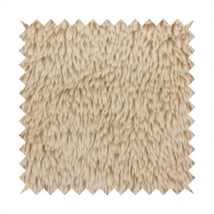 A tan or light beige, high-pile faux fur fabric. It has a dense, plush, and cosy texture with soft, slightly tousled fibres that create a shag-like appearance.