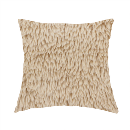 The fabric used to create this handmade cushion is a tan or light beige, high-pile faux fur fabric. It has a dense, plush, and cosy texture with soft, slightly tousled fibres that create a shag-like appearance.