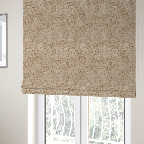 The fabric used to create these Roman blinds is a tan or light beige, high-pile faux fur fabric. It has a dense, plush, and cosy texture with soft, slightly tousled fibres that create a shag-like appearance.