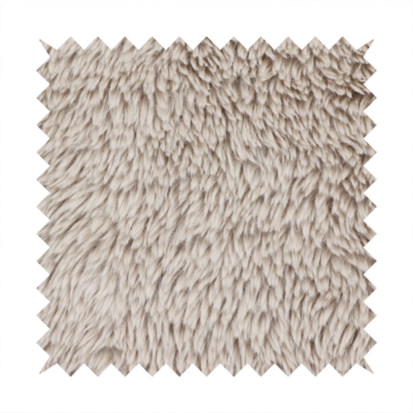 A taupe or light greyish-brown, high-pile faux fur fabric. It features a dense, plush texture with soft, tousled fibres that create a cosy, shag-like appearance.