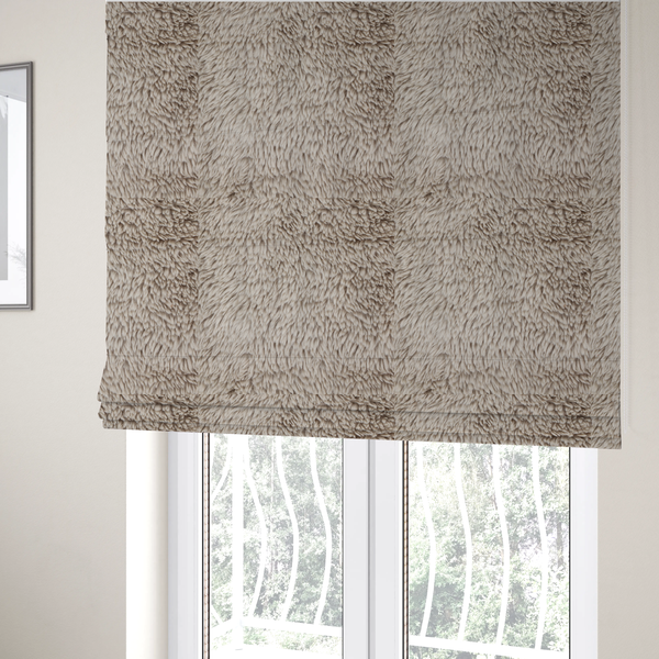 The fabric used to create these Roman blinds is a taupe or light greyish-brown, high-pile faux fur fabric. It features a dense, plush texture with soft, tousled fibres that create a cosy, shag-like appearance.