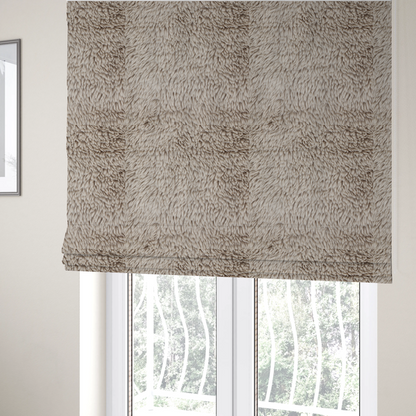 The fabric used to create these Roman blinds is a taupe or light greyish-brown, high-pile faux fur fabric. It features a dense, plush texture with soft, tousled fibres that create a cosy, shag-like appearance.