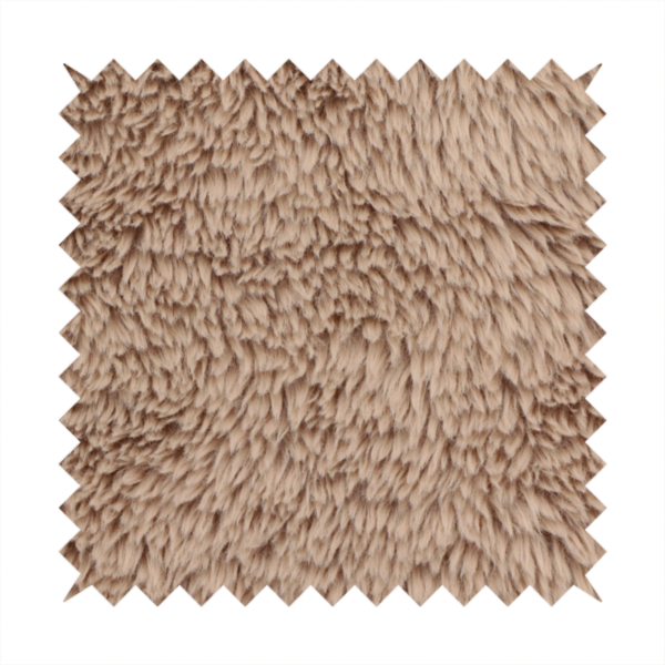 A warm beige or sandy-toned, high-pile faux fur fabric. It displays a dense, luxurious texture with soft, tousled fibres that create a cosy, shag-inspired look.
