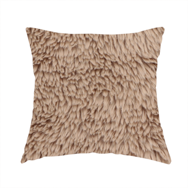 The fabric used to create this handmade cushion is a warm beige or sandy-toned, high-pile faux fur fabric. It displays a dense, luxurious texture with soft, tousled fibres that create a cosy, shag-inspired look.