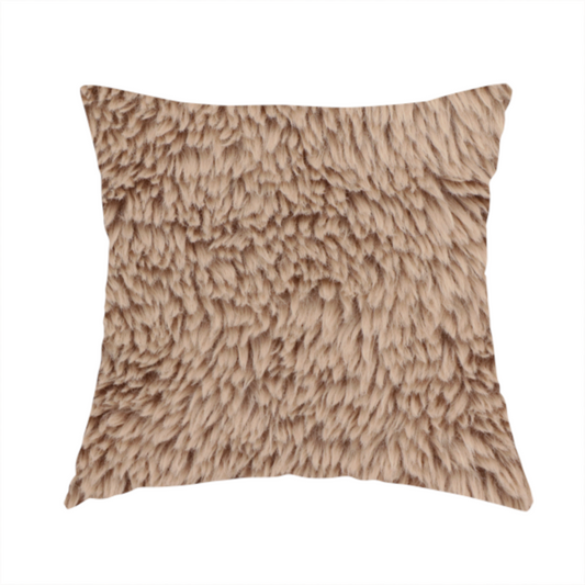 The fabric used to create this handmade cushion is a warm beige or sandy-toned, high-pile faux fur fabric. It displays a dense, luxurious texture with soft, tousled fibres that create a cosy, shag-inspired look.