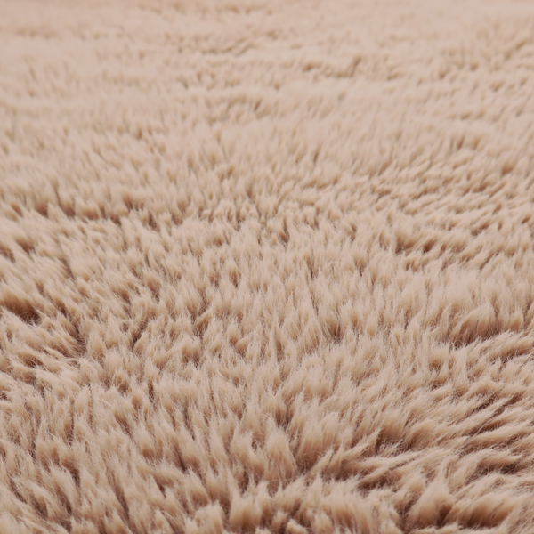A warm beige or sandy-toned, high-pile faux fur fabric. It displays a dense, luxurious texture with soft, tousled fibres that create a cosy, shag-inspired look.