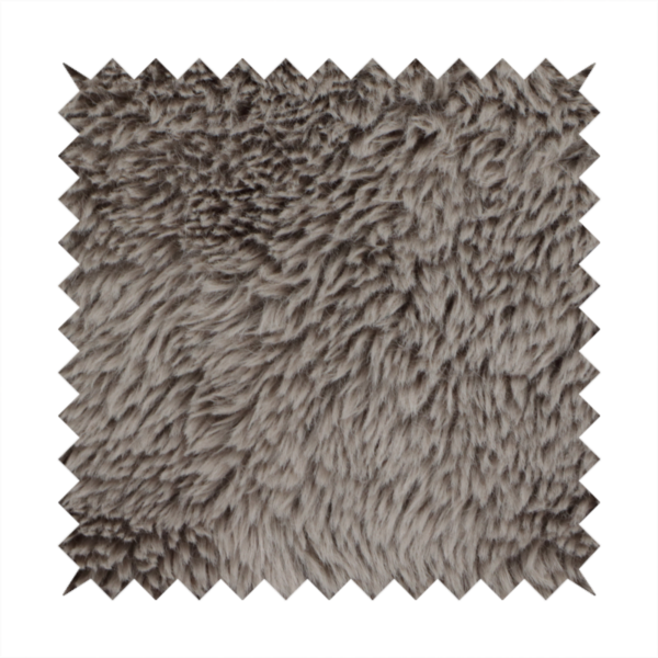 A cool-toned, greyish-brown or charcoal-taupe, high-pile faux fur fabric. It displays a dense, luxurious texture with soft, tousled fibres that create a cosy, shag-inspired look.