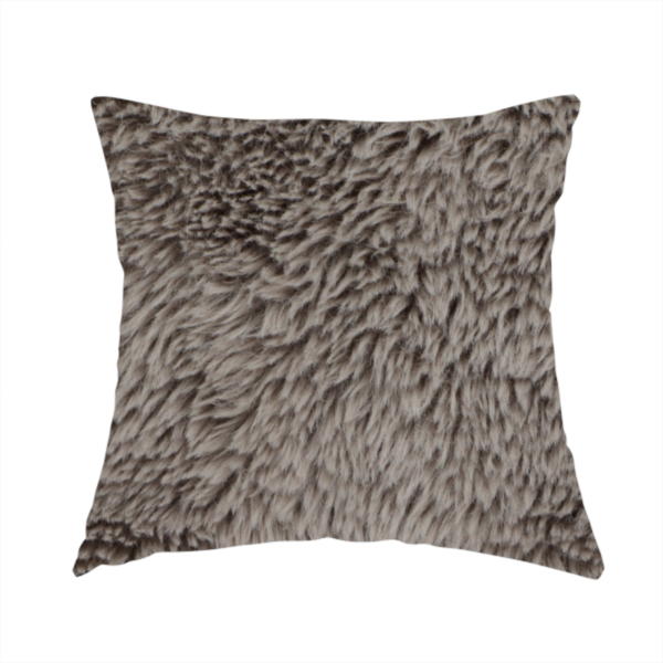 The fabric used to create this handmade cushion is a cool-toned, greyish-brown or charcoal-taupe, high-pile faux fur fabric. It displays a dense, luxurious texture with soft, tousled fibres that create a cosy, shag-inspired look.