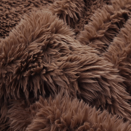 A deep, rich chocolate brown, high-pile faux fur fabric. It has a dense, luxurious texture with soft, tousled fibres that give it a warm and cosy shag-like appearance.