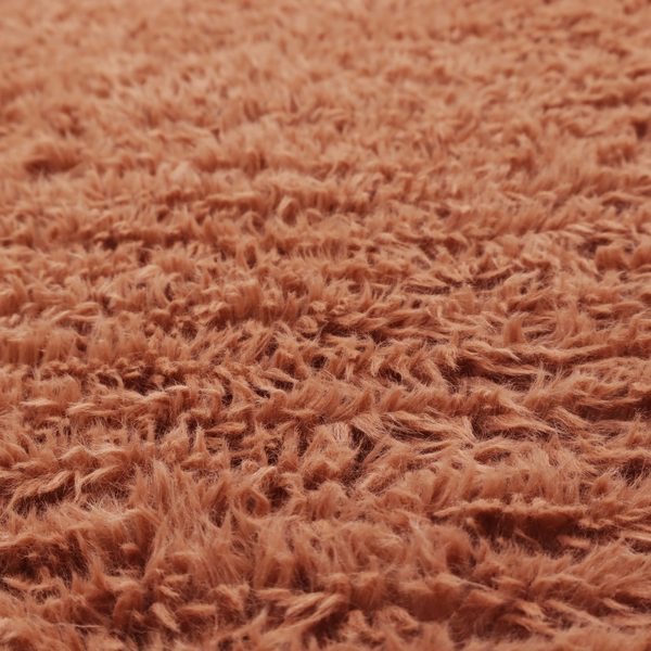 A rust or burnt-orange, high-pile faux fur fabric. It features a unique, wavy or rippled texture created by the directional alignment of the plush, soft fibres, giving it a distinctive shag-like appearance.
