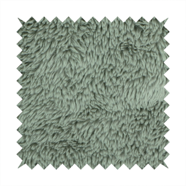A muted, sage green, high-pile faux fur fabric. It features a dense, luxurious texture with soft, tousled fibres that create a cosy, shag-like appearance.