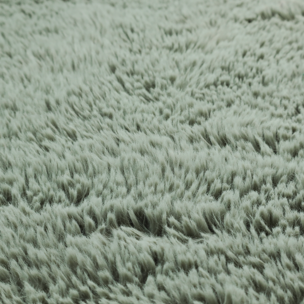 A muted, sage green, high-pile faux fur fabric. It features a dense, luxurious texture with soft, tousled fibres that create a cosy, shag-like appearance.