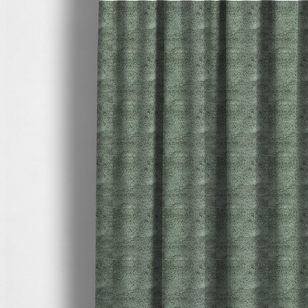 The fabric used to create these made-to-measure curtains is a muted, sage green, high-pile faux fur fabric. It features a dense, luxurious texture with soft, tousled fibres that create a cosy, shag-like appearance.