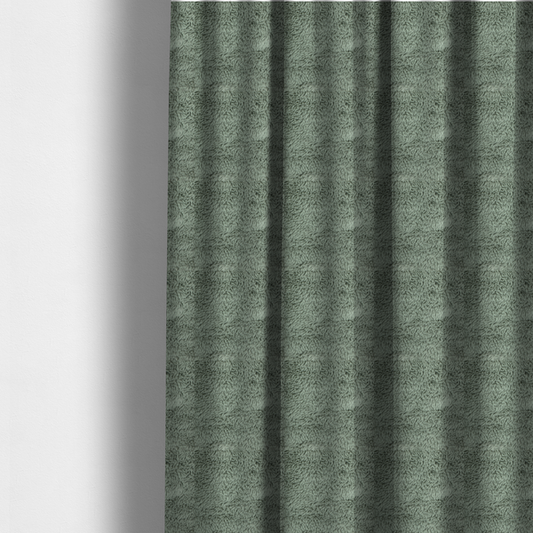 The fabric used to create these made-to-measure curtains is a muted, sage green, high-pile faux fur fabric. It features a dense, luxurious texture with soft, tousled fibres that create a cosy, shag-like appearance.