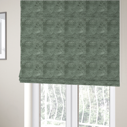The fabric used to create these Roman blinds is a muted, sage green, high-pile faux fur fabric. It features a dense, luxurious texture with soft, tousled fibres that create a cosy, shag-like appearance.