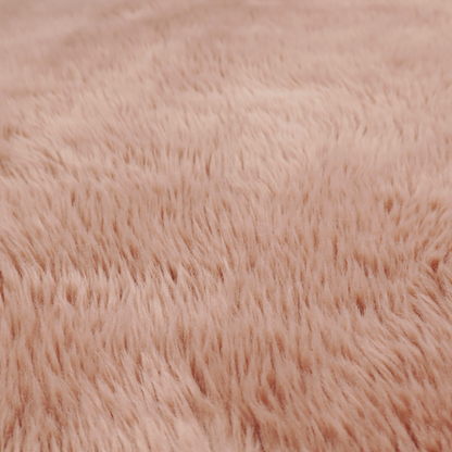 A dusty rose or soft mauve, high-pile faux fur fabric. It features a dense, luxurious texture with soft, tousled fibres that create a cosy, shag-like appearance.
