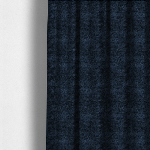 The fabric used to create these made-to-measure curtains is a deep navy blue, high-pile faux fur fabric. It displays a dense, luxurious texture with soft, slightly tousled fibres that create a cosy and sophisticated shag-like appearance.