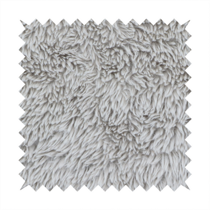A cool-toned, light silver-grey high-pile faux fur fabric. It has a dense, plush texture characterized by soft, tousled fibres that create a cosy, shag-like appearance.