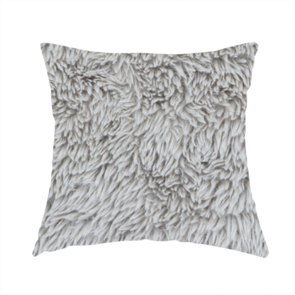 The fabric used to create this handmade cushion is a cool-toned, light silver-grey high-pile faux fur fabric. It has a dense, plush texture characterized by soft, tousled fibres that create a cosy, shag-like appearance.